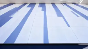 Parete con design astratto a strisce verticali blu e bianche in un edificio moderno